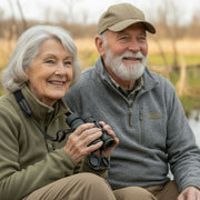 Senior couple with binoculars sitting in a wetland  environment