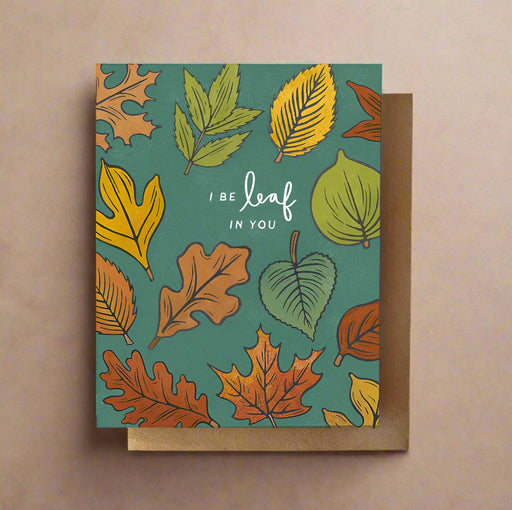 Greeting card with leaf pattern and text 'I BE leaf IN YOU' on a teal background