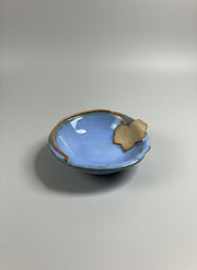 Small blue ceramic dish with a rustic leaf trim on a gray background