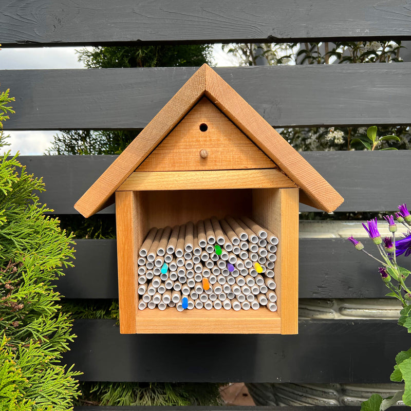 Chalet Bee House and Bee Cocoon Hatchery™ Combo
Bee tubes not included
Wooden bee house with tubes for bees against a wooden fence background