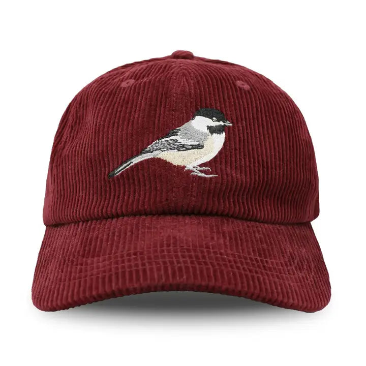 burgundy red corduroy cap with a bird embroidered on a white background