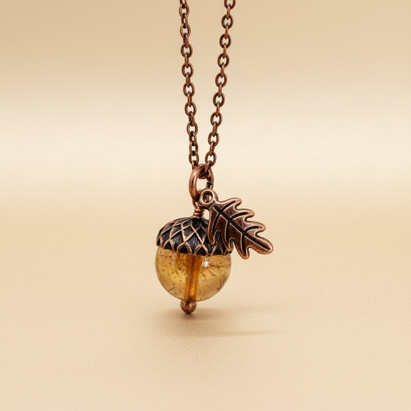 Necklace with acorn pendant and leaf charm on a warm background