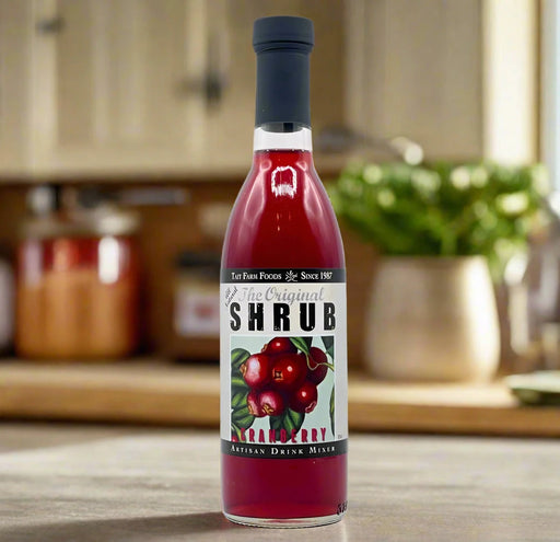 Cranberry shrub on a kitchen counter with food ingredients in the background