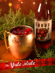Copper mug with a drink and bottle labeled 'Shrub' on a festive background