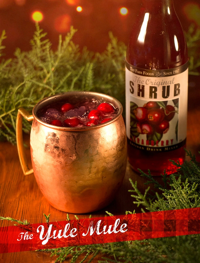 Copper mug with a drink and bottle labeled 'Shrub' on a festive background