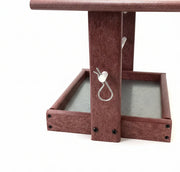 Cherrywood cylinder feeder with metal clip to secure cylinder rod and metal mesh tray for drainage.