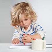 Child coloring with beeswax crayons on a pad of paper