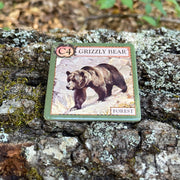 Game card featuring a grizzly bear on a lichen-covered log