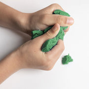 Hands playing with green eco-dough on a white background