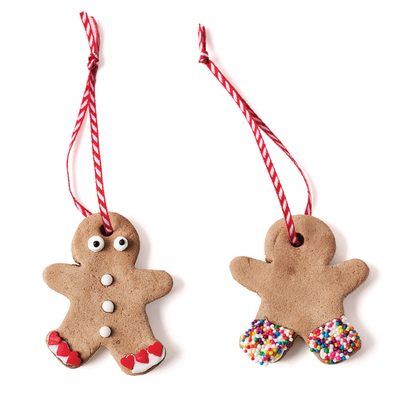 two homemade gingerbread man ornaments decorated and string with white and red striped string