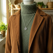 Necklace with a pendant on a mannequin bust against a shop background