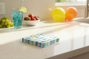 Stack of Aquarell Fish napkins on a countertop next to balloons, bowls of fruit and summery drink.