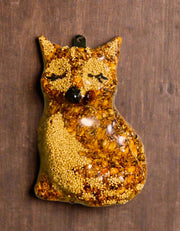 Shrink-wrapped Fox seed ornament with hanger installed on a wooden background