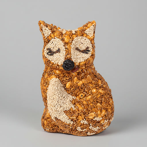 Fox-shaped bird ornament made of seeds, peanuts and mealworms on a blurred background