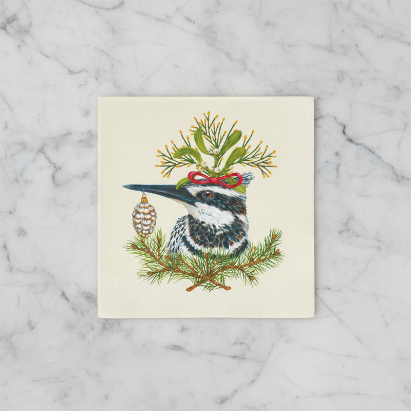 Paper napkin featuring a kingfisher bird, festive greens on a off-white background on a marble countertop