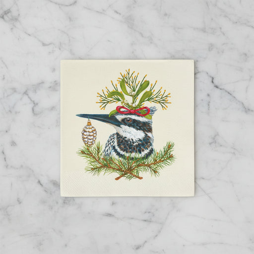 Paper napkin featuring a kingfisher bird, festive greens on a off-white background on a marble countertop