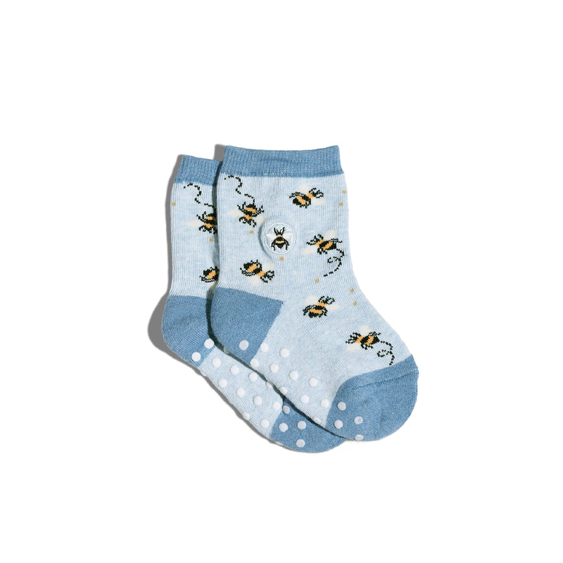Pair of light blue preschool size socks with bee pattern and sticky dot feet on a white background