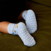 Baby's feet wearing light blue socks with white grippy dots 
