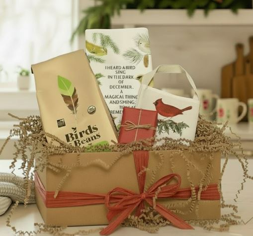 Gift basket with a towel, card, and package on a table with a blurred background