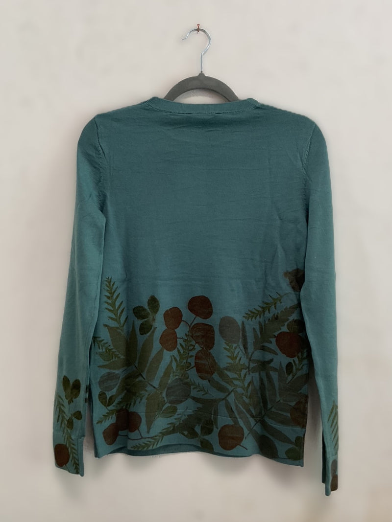 Teal long-sleeve sweater with floral pattern on a hanger against an off-white background - back view