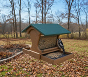 Mini Magnet Hanging Recycled Feeder hanging in a backyard in late autumn. Downy woodpecker enjoying the birdseed