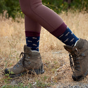 Person wearing hiking boots and patterned moose socks in a natural setting