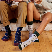 Two people sitting on the floor wearing patterned moose and bear socks
