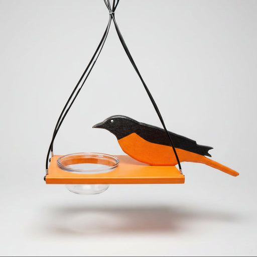 Bird-shaped feeder with orange and black design on a white background