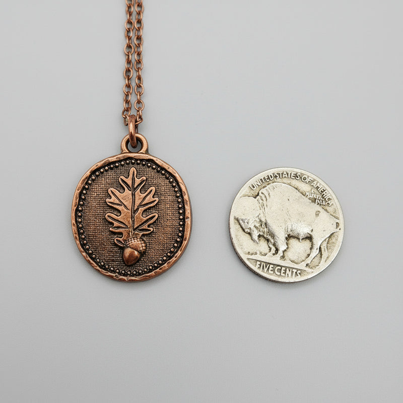 Copper pendant with oak leaf and acorn design and Buffalo Nickel coin for size comparison