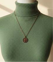 Necklace with a pendant on a mannequin bust against a neutral background