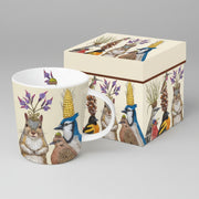 Mug with nature-themed design featuring animals with plant hats, next to a matching box.
