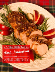 Sliced pork tenderloin with apple chutney on a plate with rosemary and apples, set against a plaid background.
