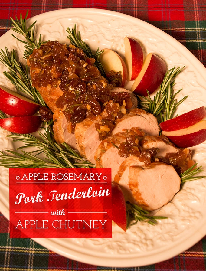Sliced pork tenderloin with apple chutney on a plate with rosemary and apples, set against a plaid background.
