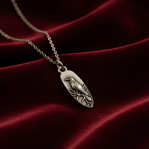 Silver pendant with raven design on a warm background