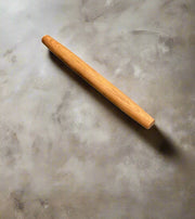 Medium size Wooden rolling pin on a textured gray surface