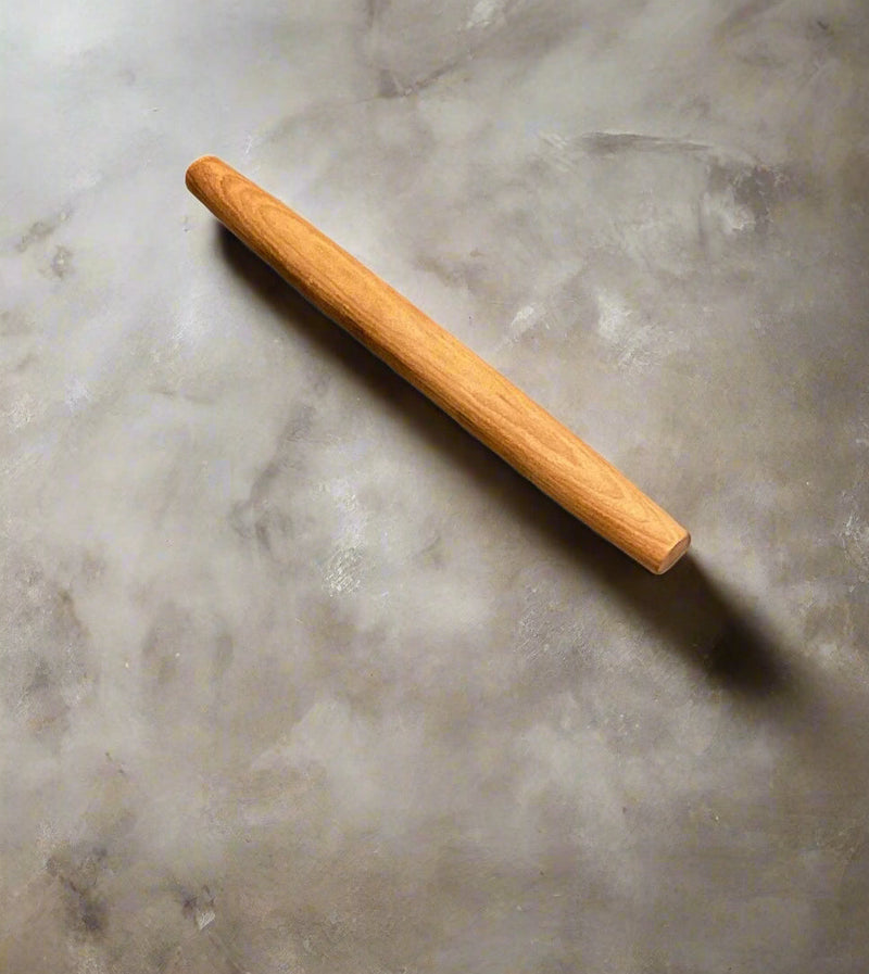 Medium size Wooden rolling pin on a textured gray surface