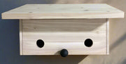 Natural Wood Roosting Box against a neutral outdoor wall - front view