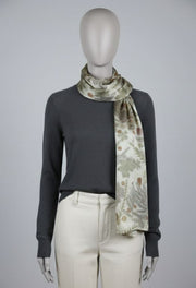 Mannequin wearing a dark gray sweater and light-colored pants with a floral-patterned scarf.