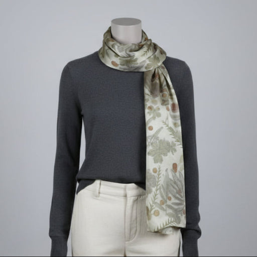 Mannequin wearing a dark gray sweater and light-colored pants with a floral-patterned scarf.