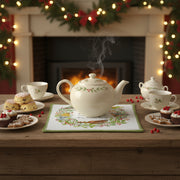 Decorative hot pad with birds, berries, and a wreath design on a white background in use during a festive tea party with fireplace in the background.