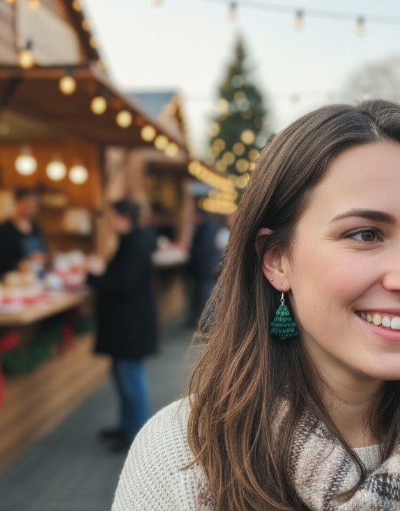Woman wearing holiday tree earrings at a outdoor Christmas market