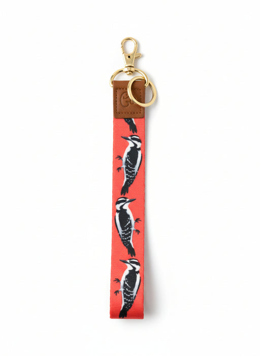 Keychain with woodpecker design on a red background