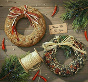 Two woven wreaths with decorative elements on a wooden surface.