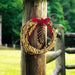 Rustic Bird Seed Wreath - 10″ - displayed on fence post