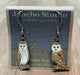 Barn Owl Earrings on cardboard