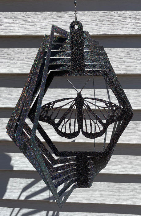 Monarch Wind Spinner in Rainbow Black with siding background
