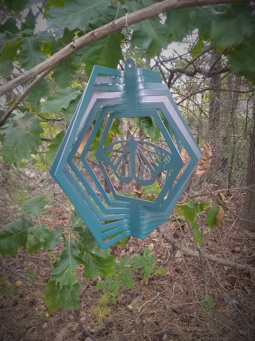 Monarch Wind Spinner in Blue Copper with woodland background