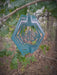 Monarch Wind Spinner in Blue Copper with woodland background